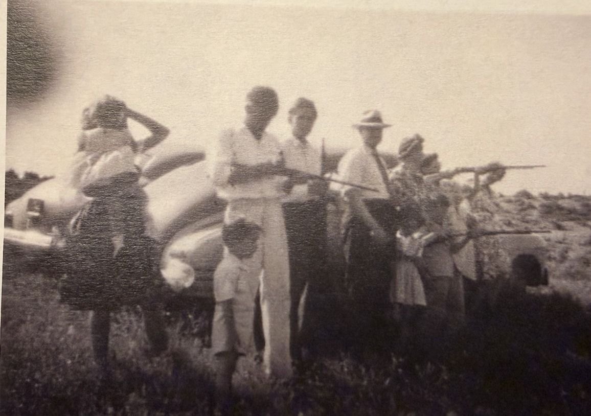The Holbrook family lined up by the Jordan River in Lehi in 1944, shooting .22s at tin cans