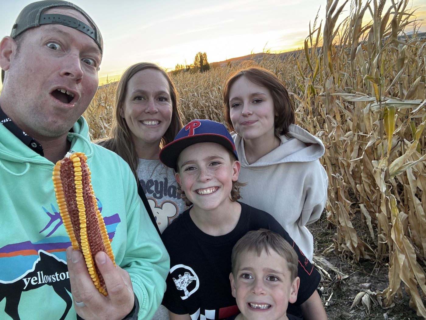 Franco Preston family selfie in a corn field with a giant ear of corn