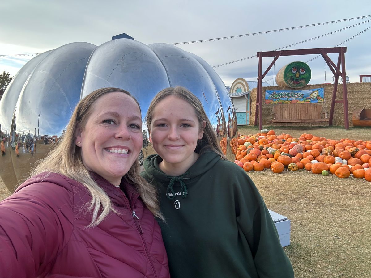 Jodi and Kyli in front of the giant mirrored pumpkin at Cornbelly's in Lehi.